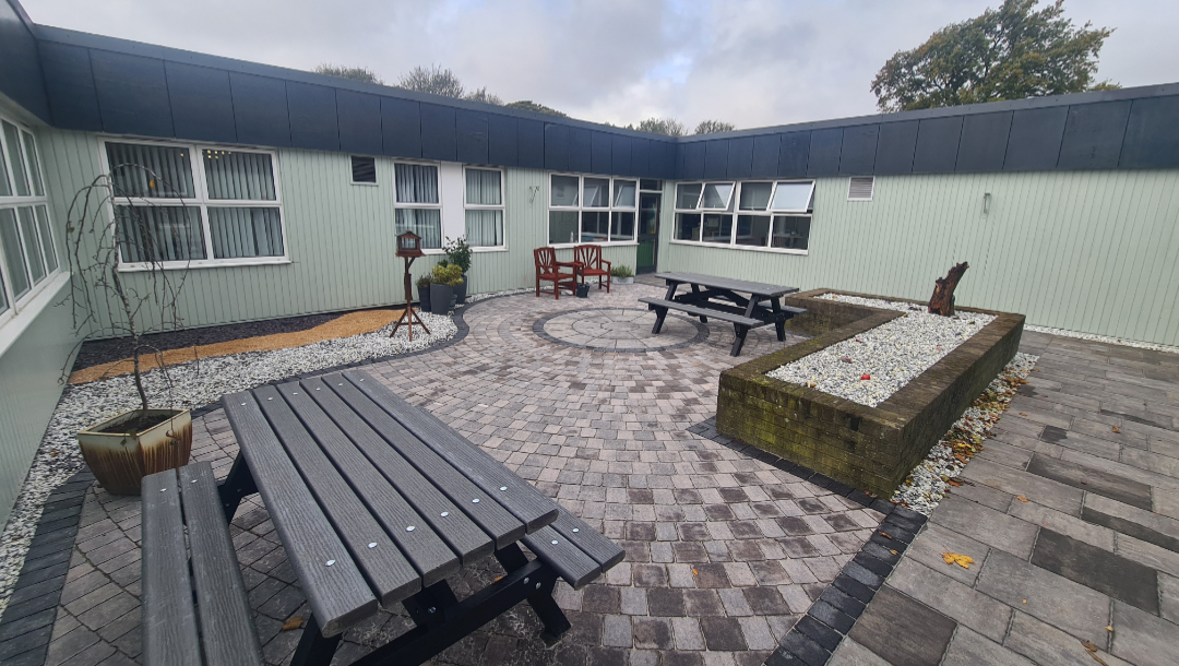 Courtyard featuring picnic tables, plants and seating.